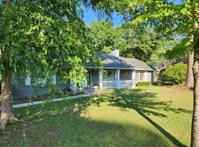 view of front of house featuring covered porch and a front yard