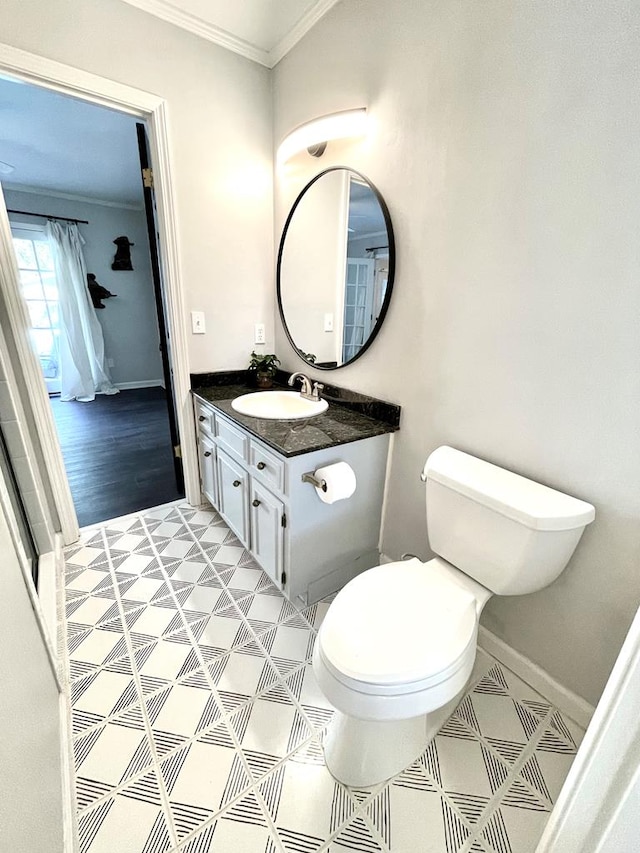 bathroom with crown molding, vanity, and toilet