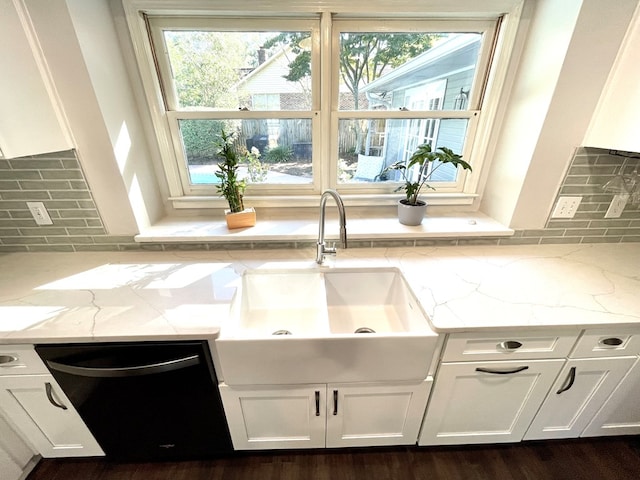 kitchen featuring white cabinetry, plenty of natural light, light stone counters, and sink