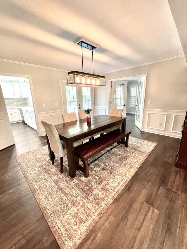 dining area featuring french doors, dark hardwood / wood-style flooring, and crown molding