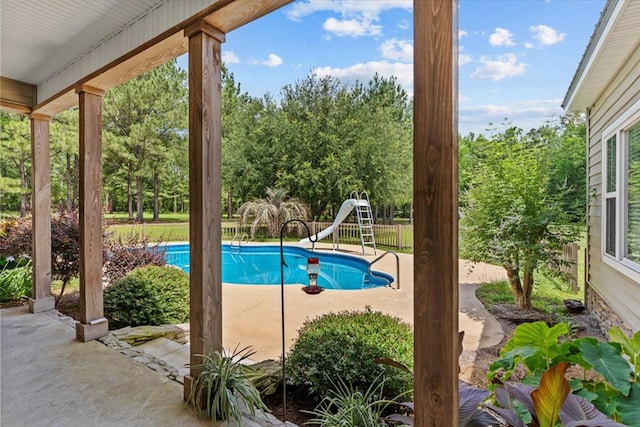 3195 Singletary Rd, Slocomb, AL 36375 - view of swimming pool with a water slide, a patio area, and view of wooded area