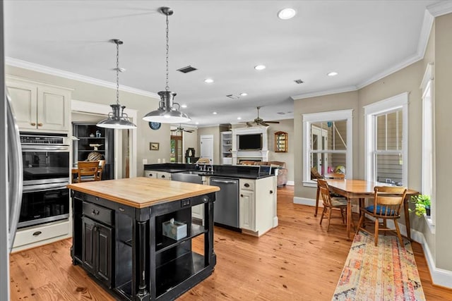3195 Singletary Rd, Slocomb, AL 36375 - kitchen featuring stainless steel appliances, dark cabinetry, a kitchen island, butcher block counters, and ceiling fan