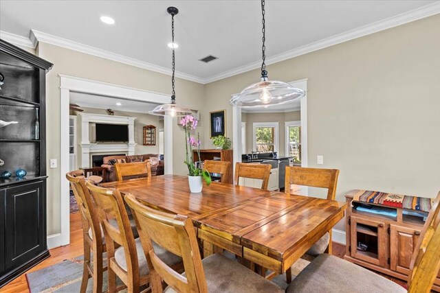3195 Singletary Rd, Slocomb, AL 36375 - dining space with crown molding, light wood-type flooring, a fireplace, and recessed lighting