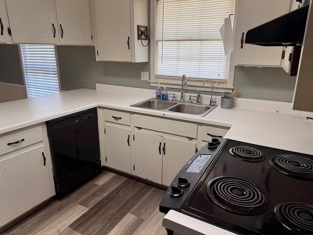 kitchen featuring exhaust hood, a sink, white cabinets, light countertops, and black appliances