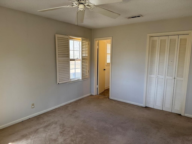 unfurnished bedroom with light carpet, baseboards, visible vents, a textured ceiling, and a closet