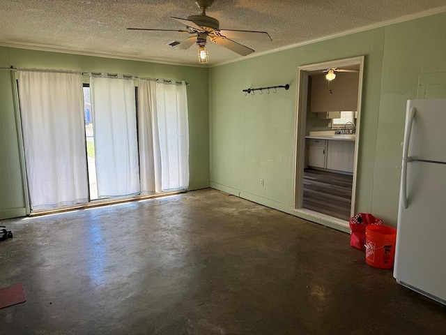 empty room featuring concrete flooring, crown molding, a textured ceiling, and a sink