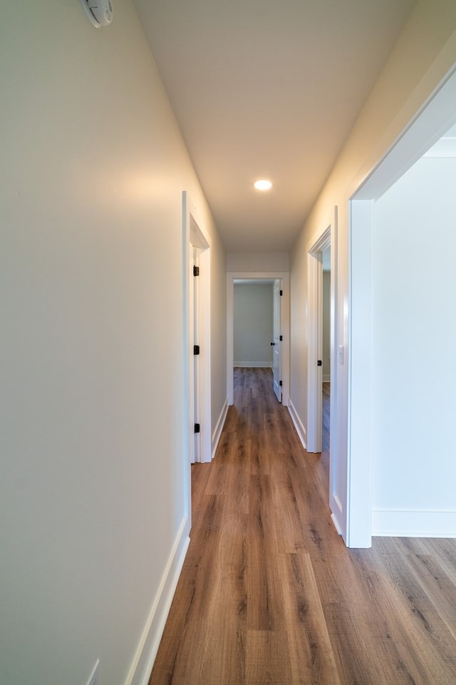 corridor with wood finished floors and baseboards