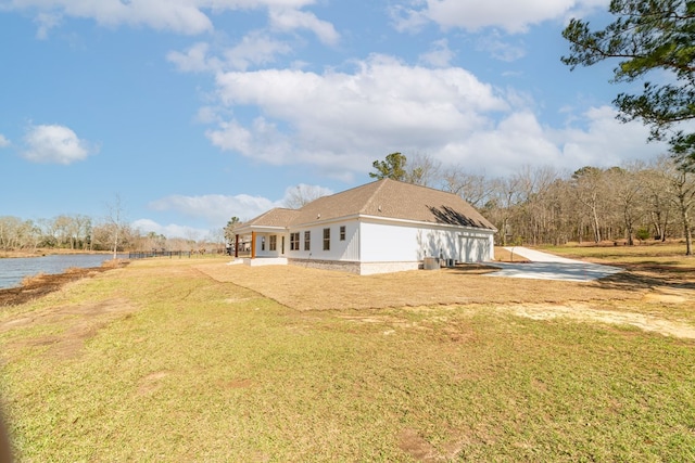 view of side of home featuring a patio area, a lawn, and driveway