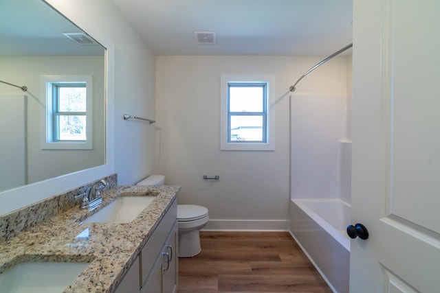 bathroom with a wealth of natural light, wood finished floors, a sink, and visible vents