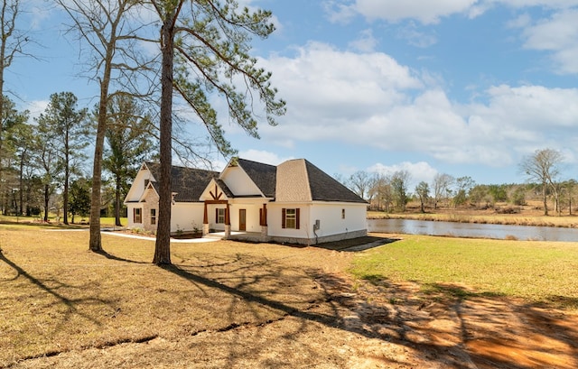 rear view of property with a lawn and a water view