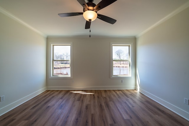 spare room with ornamental molding, dark wood-type flooring, and baseboards