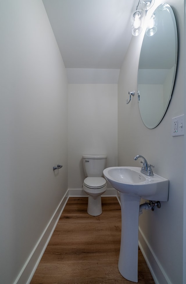 bathroom with wood finished floors, toilet, and baseboards