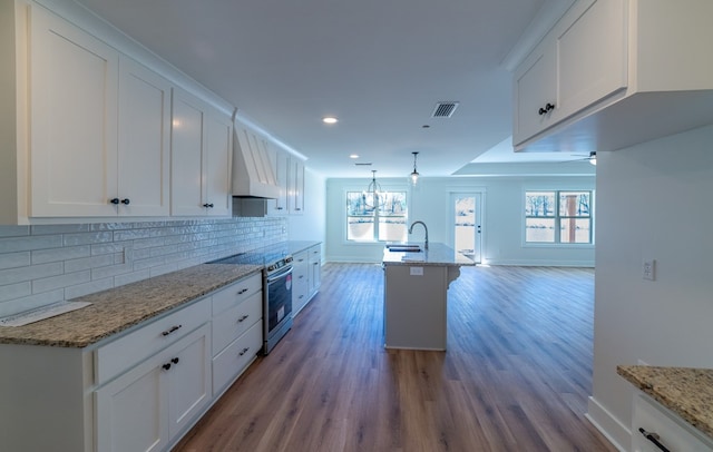 kitchen with light stone counters, visible vents, white cabinetry, electric stove, and decorative light fixtures