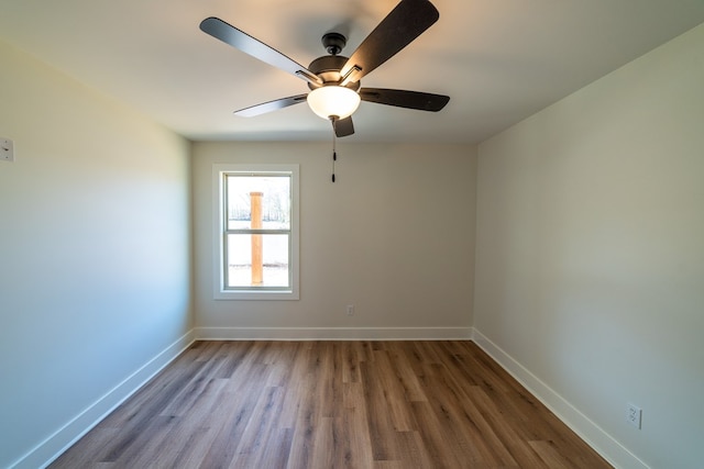 spare room featuring ceiling fan, baseboards, and wood finished floors