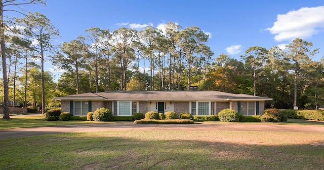 single story home featuring a front yard and concrete driveway