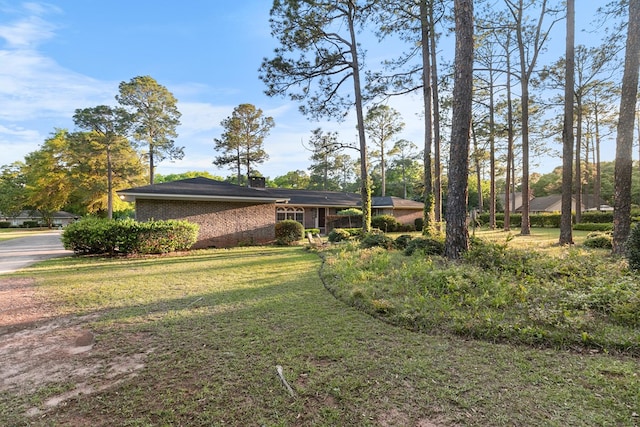 exterior space with brick siding and a front yard