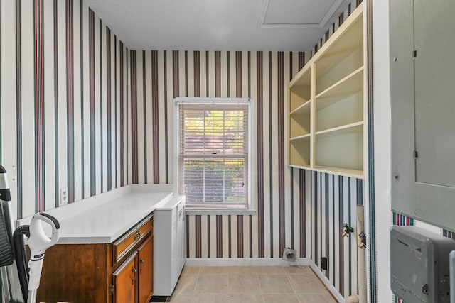 interior space with light tile patterned floors, baseboards, laundry area, and wallpapered walls