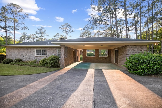 ranch-style home featuring a carport, driveway, and brick siding