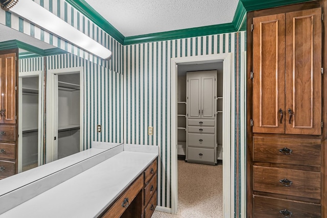 interior space featuring baseboards, a textured ceiling, wallpapered walls, and crown molding