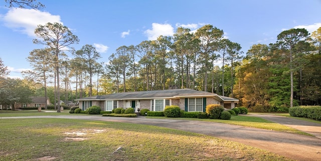 single story home featuring curved driveway and a front lawn
