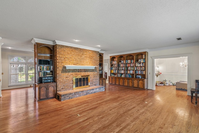 living room featuring a textured ceiling, crown molding, and wood finished floors