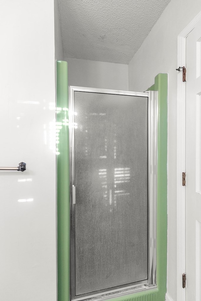 details featuring a stall shower and a textured ceiling