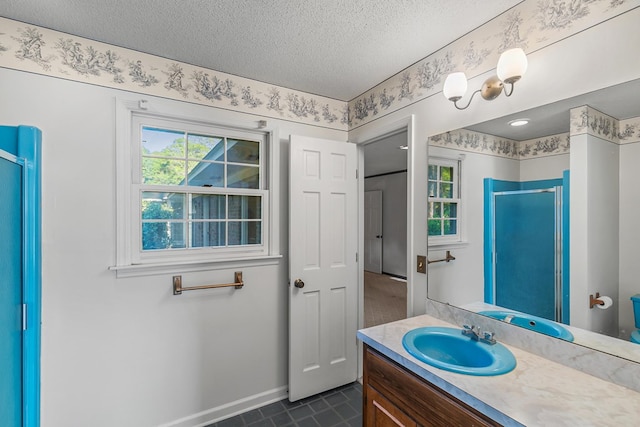 full bathroom with vanity, baseboards, tile patterned flooring, a textured ceiling, and a shower stall