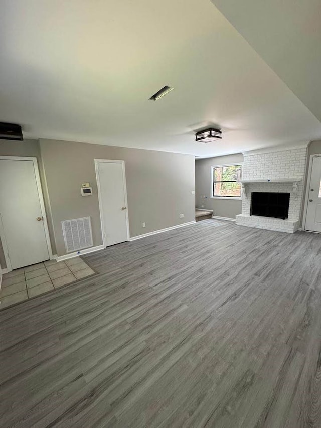 107 Comanche Cir, Enterprise, AL 36330 - unfurnished living room featuring wood finished floors and a brick fireplace