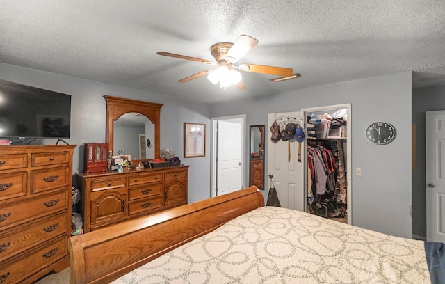 bedroom featuring ceiling fan, a closet, a spacious closet, and a textured ceiling