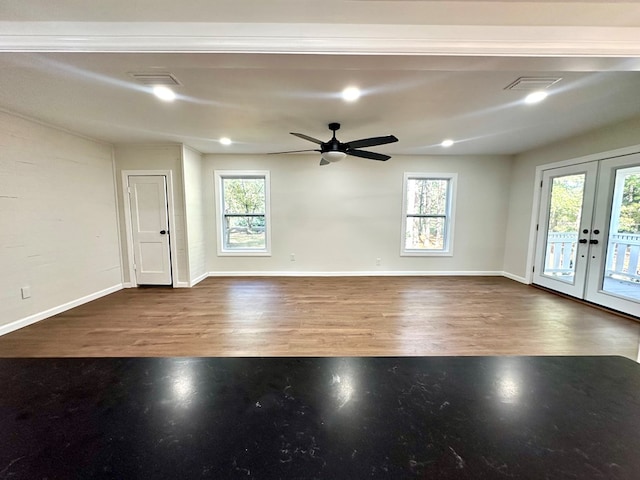 spare room featuring plenty of natural light, wood-type flooring, and french doors