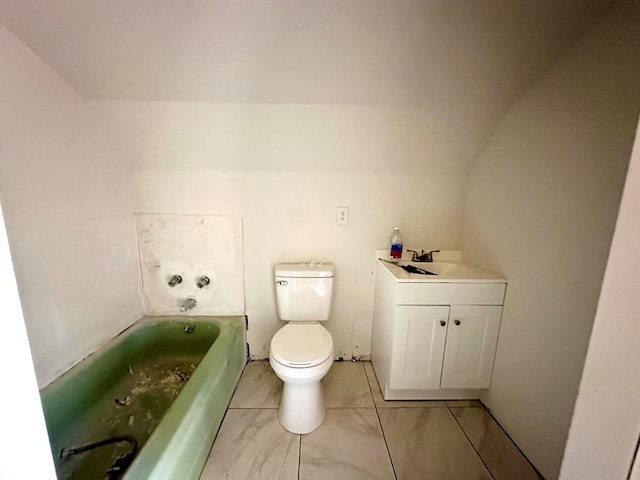 bathroom featuring vanity, toilet, lofted ceiling, and a tub to relax in