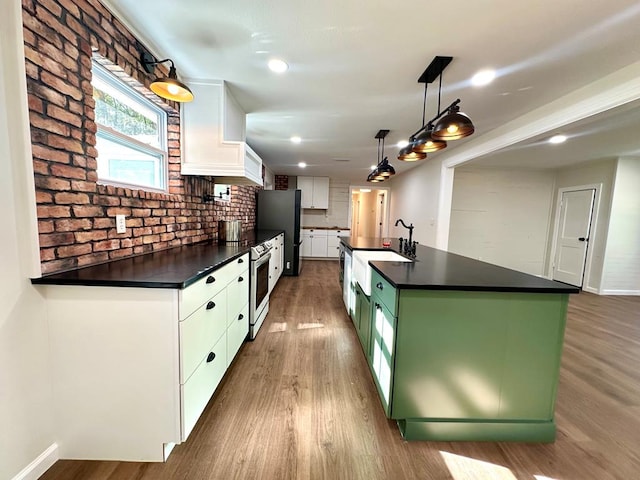 kitchen featuring tasteful backsplash, pendant lighting, a center island with sink, hardwood / wood-style flooring, and white cabinetry