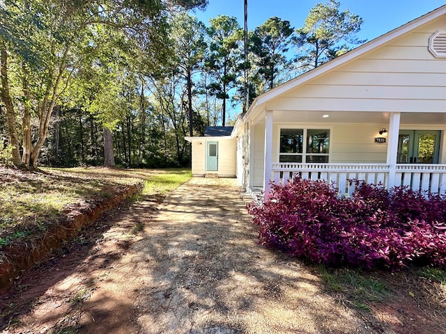 view of side of property featuring covered porch