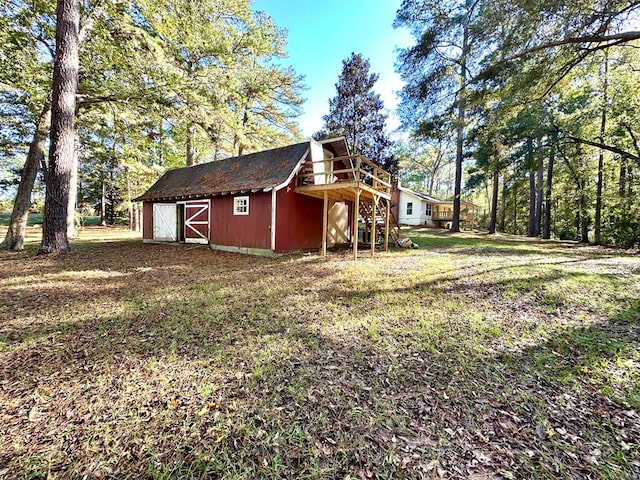 exterior space with a lawn, an outdoor structure, and a deck