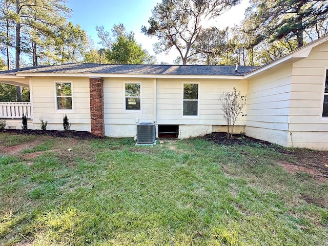 rear view of house with a yard and cooling unit