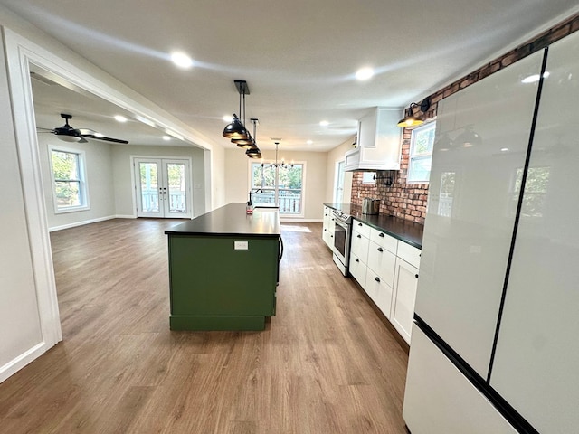 kitchen featuring a wealth of natural light, white cabinetry, hanging light fixtures, and a kitchen island