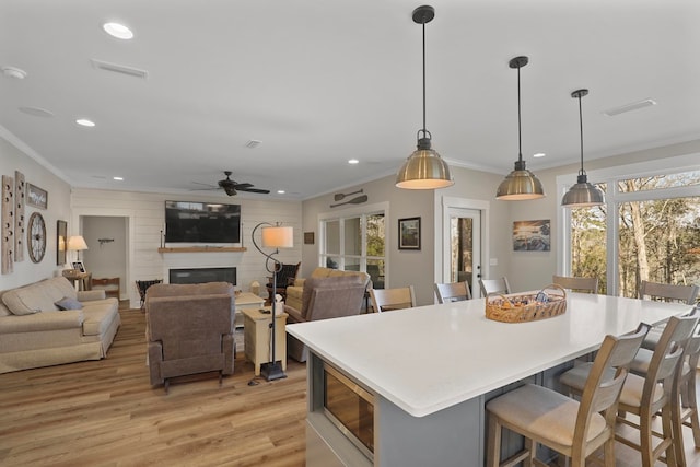 kitchen with crown molding, a breakfast bar area, and pendant lighting