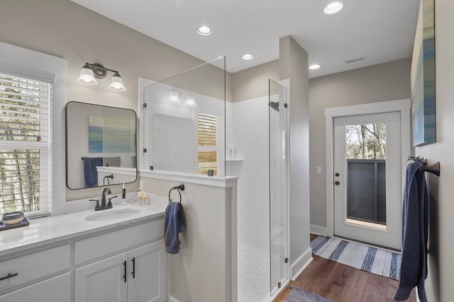 bathroom featuring tiled shower, vanity, and hardwood / wood-style floors