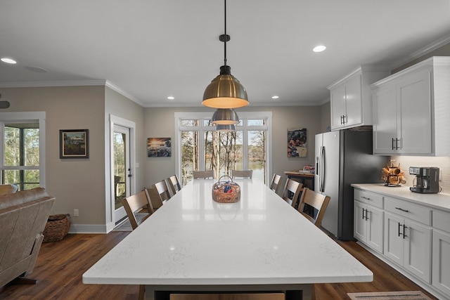 dining area with ornamental molding and dark hardwood / wood-style floors