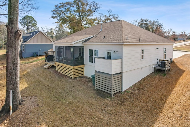 rear view of house with a sunroom and a yard