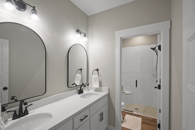 bathroom with an enclosed shower, vanity, hardwood / wood-style flooring, and toilet