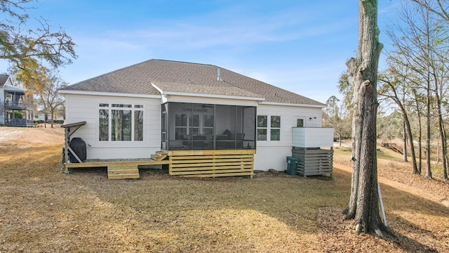 rear view of property featuring a sunroom and a lawn