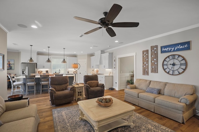 living room featuring crown molding, ceiling fan, and hardwood / wood-style flooring