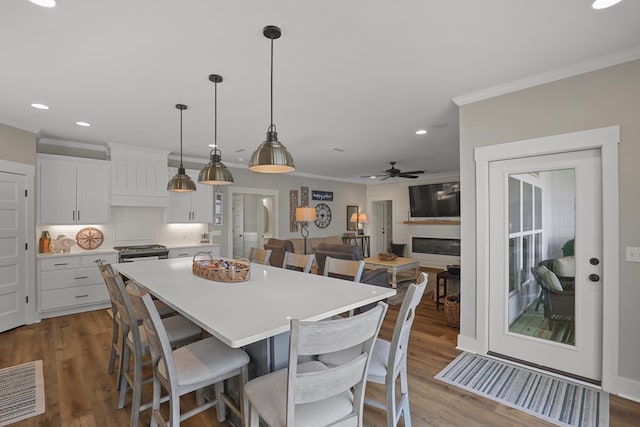 dining space with ceiling fan, ornamental molding, and hardwood / wood-style floors