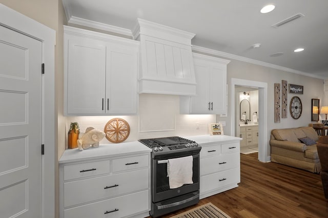 kitchen featuring ornamental molding, gas stove, decorative backsplash, and white cabinets