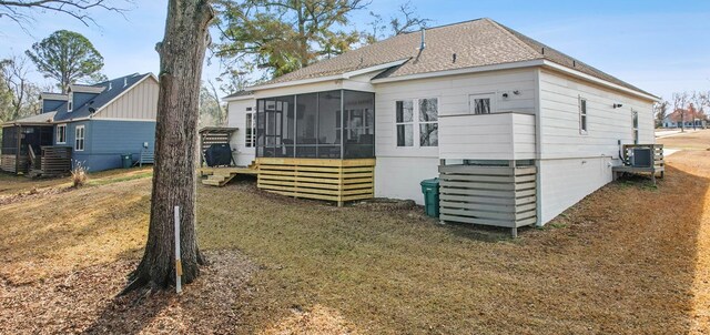 back of property with a yard, central AC, and a sunroom