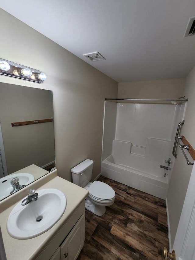 full bathroom featuring hardwood / wood-style floors, vanity, toilet, and shower / washtub combination