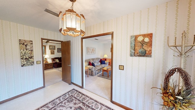 corridor featuring carpet flooring and an inviting chandelier