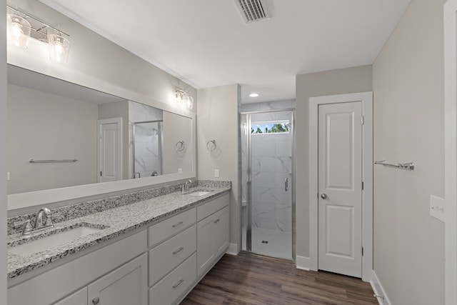 bathroom featuring walk in shower, vanity, and hardwood / wood-style flooring