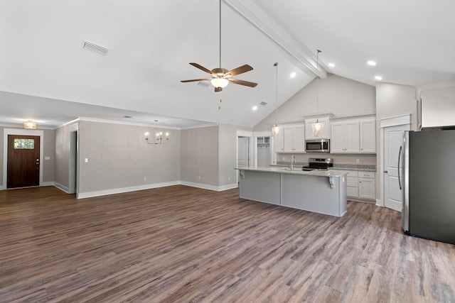 kitchen featuring beam ceiling, an island with sink, wood-type flooring, white cabinets, and appliances with stainless steel finishes